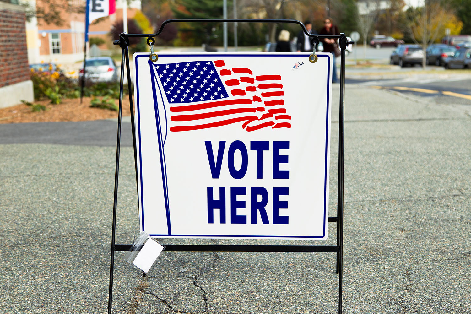 A Vote Here sign is set up in a parking lot